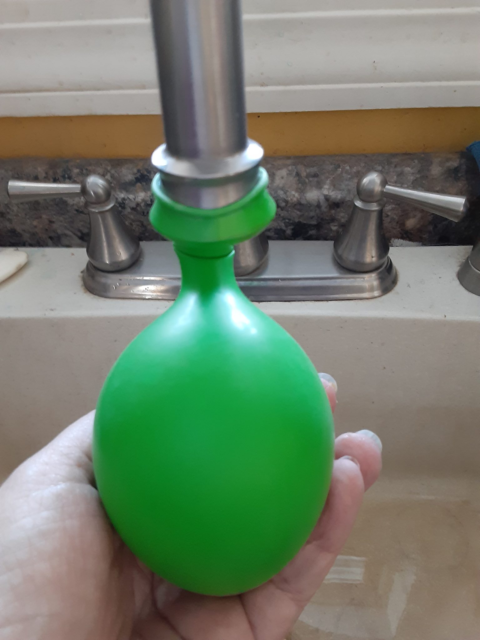balloon wrapped on faucet head to add water to make the ice balls