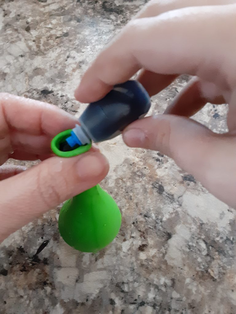 Adding food coloring to water balloon