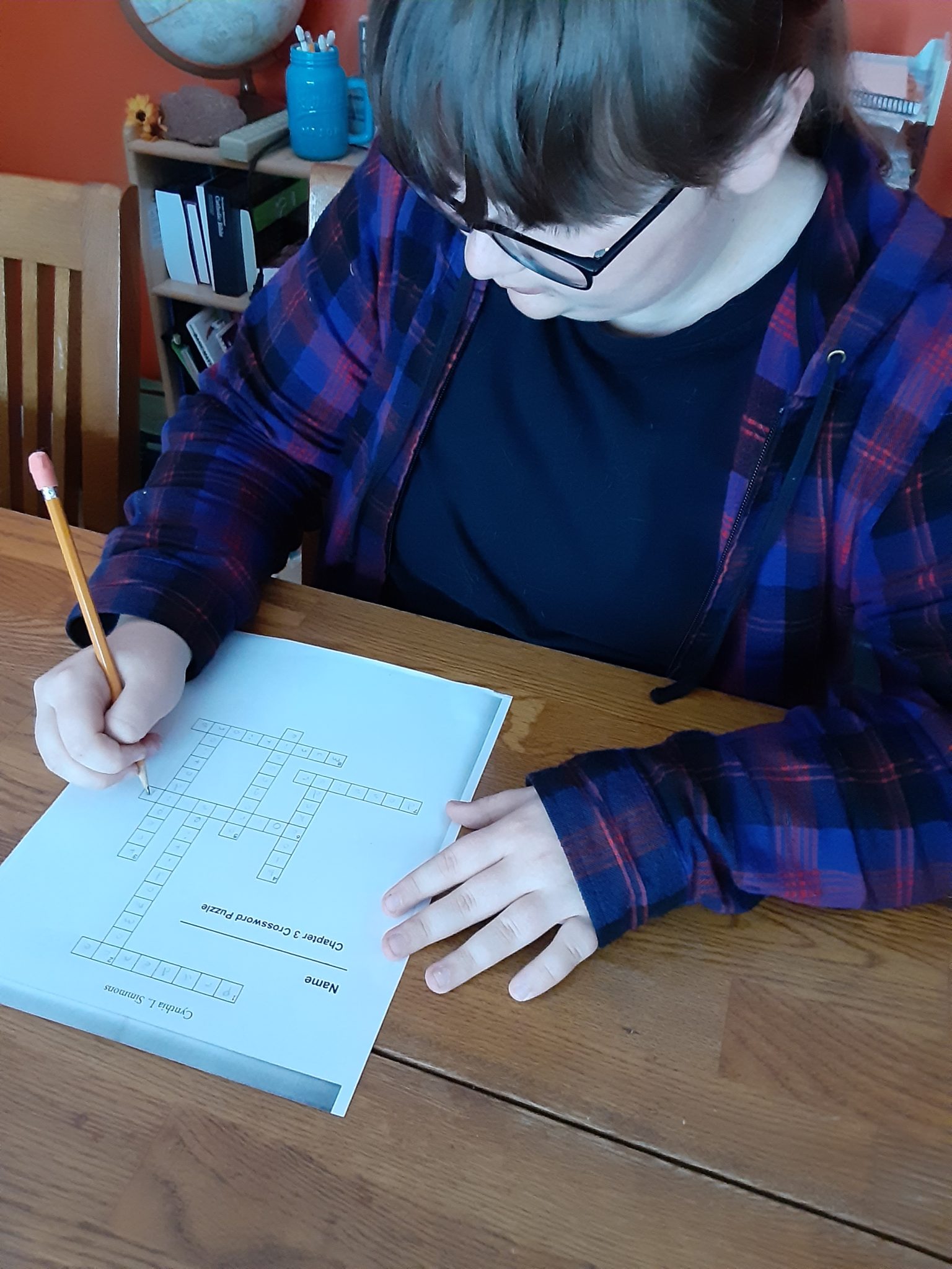 Teen working on crossword puzzle for Pursuing Gold