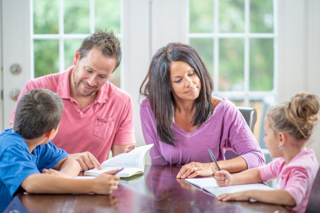 homeschooling family sitting around table; homeschooling is hard but worth it